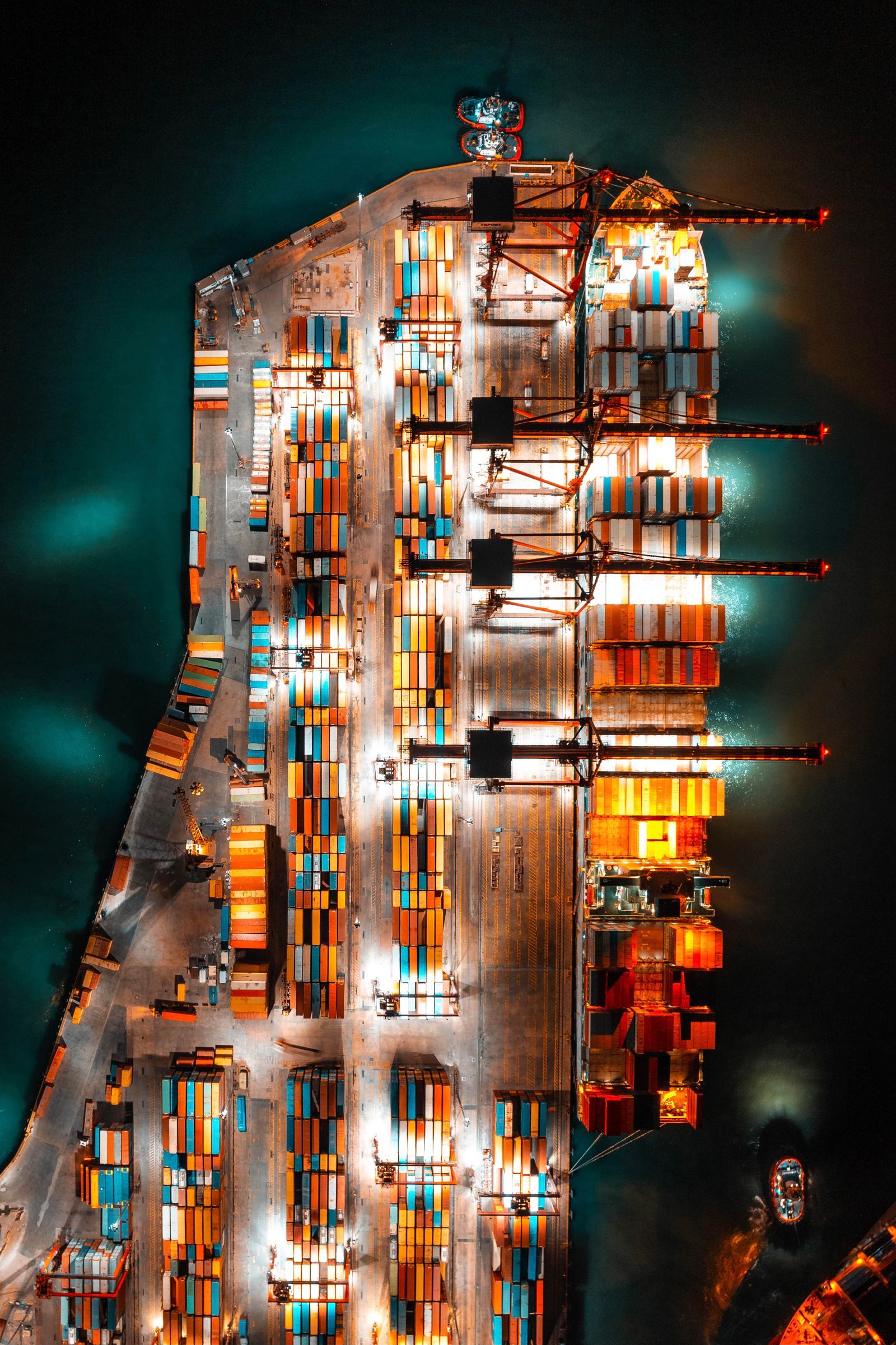 A container terminal lit at night, seen from above — illustrative photography, not a Corridor Freight facility